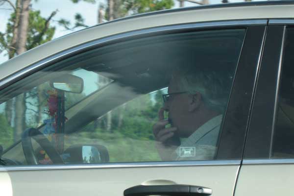 Man driving on the Interstate while playing the harmonica